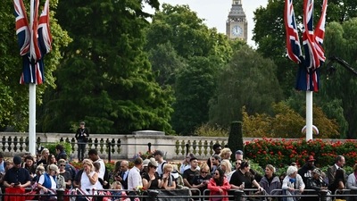 Members of the public wait in London head of the ceremonial procession of the coffin of Queen Elizabeth II, from Buckingham Palace to Westminster Hall. (AFP) Members of the public wait in London head of the ceremonial procession of the coffin of Queen Elizabeth II, from Buckingham Palace to Westminster Hall. (AFP)