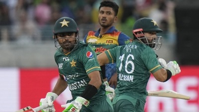 Sri Lanka's Dilshan Madushanka, center, watches as Pakistan's captain Babar Azam, left, and Mohammad Rizwan run between the wickets. (AP)