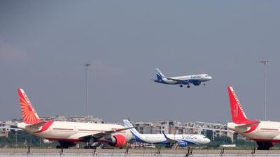 An aircraft operated by IndiGo, a unit of InterGlobe Aviation Ltd., prepares to land as Air India Ltd. aircraft are on the tarmac at the Indira Gandhi International Airport in New Delhi, India, on Tuesday, Sept. 28 2021. The India government is attempting to sell state-run Air India after two failed attempts. Despite the mounting debt and losses, the airline has some lucrative assets, including valued slots at London's Heathrow airport, a fleet of more than 100 planes and thousands of trained pilots and crew. Photographer: T. Narayan/Bloomberg (Bloomberg)