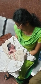 The medico looking at the baby girl she helped deliver in a moving train. (Sourced) The medico looking at the baby girl she helped deliver in a moving train. (Sourced)