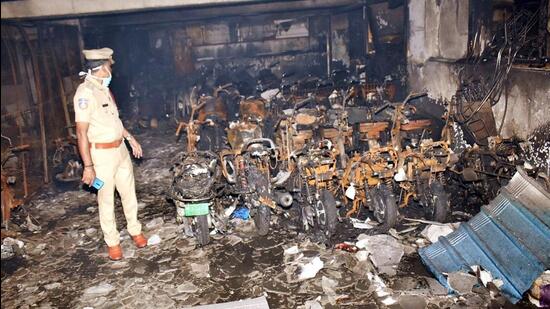 Hyderabad, Sep 13 (ANI): Police personnel stand near the charred remains of electric scooties that were parked in the basement of a hotel after a fire broke out in the ground floor, at Secunderabad, in Hyderabad on Tuesday. Reportedly six people were killed in the incident. (ANI Photo) (Mohammed Aleemuddin)