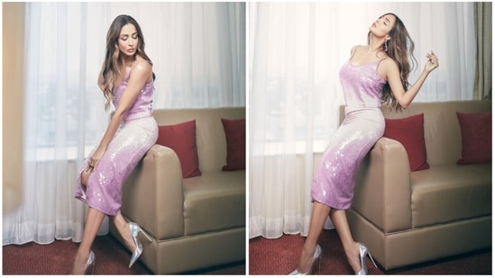 Fitness and fashion enthusiast Malaika Arora is often making headlines for her unconventional style. When it comes to bodycon dresses, her curves do perfect justice to them. In her recent photoshoot images from her living room, Malaika rocked the pink retro sequins dress featuring a front slit.(Instagram/@malaikaaroraofficial)