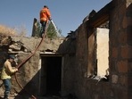 Armenia- Azerbaijan Conflict: Firefighters water the ruins of a house, which is said was hit by Azeri shelling during recent border clashes with Azerbaijan.