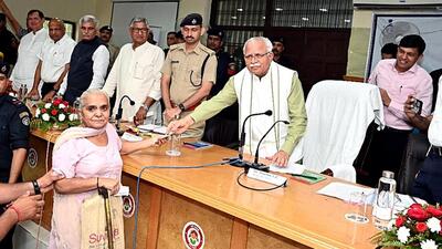 Haryana chief minister Manohar Lal Khattar while giving a pension of  ₹2,500 from his pocket to an elderly woman during the mass dialogue program organised in Rohtak. He immediately ordered the officers to restore the pension of the elderly woman. (Manoj Dhaka/HT)