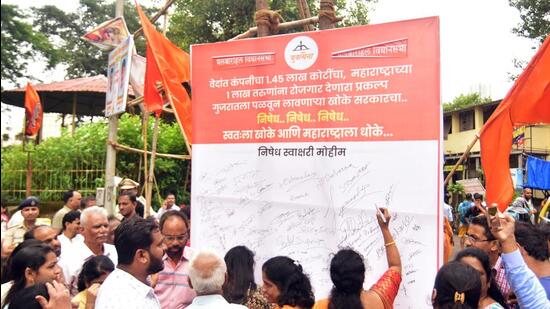 MYuva Sena members sign the board as part of protest against the shifting of Vedanta-Foxconn semiconductor manufacturing project from Maharashtra to Gujarat at Tardeo in Mumbai on Thursday (ANI) MYuva Sena members sign the board as part of protest against the shifting of Vedanta-Foxconn semiconductor manufacturing project from Maharashtra to Gujarat at Tardeo in Mumbai on Thursday (ANI)
