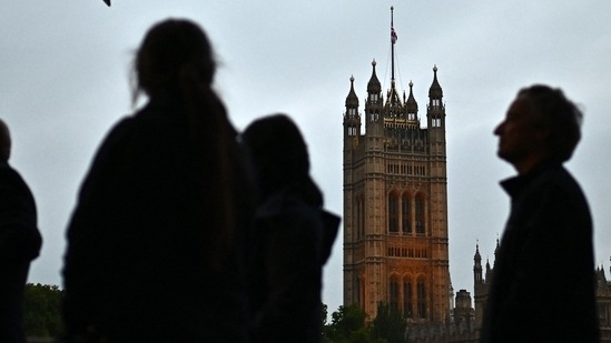 Queen Elizabeth II Funeral: Members of the public stand in the queue, opposite the Victoria Tower of the Palace of Westminster.(AFP)