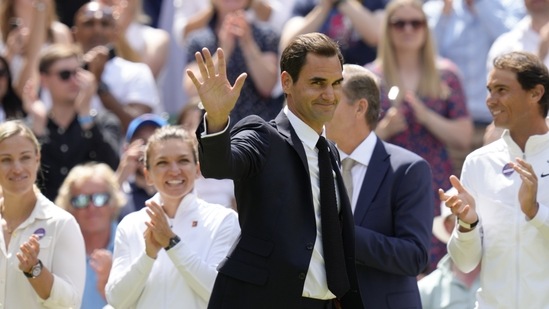 Former Wimbledon singles champion Roger Federer is applauded as he arrives to take part in a 100 years of Centre Court celebration on day seven of the Wimbledon tennis championships in London(AP)