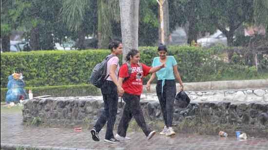 Students caught in the rain at Panjab University in Chandigarh. (Ravi Kumar/HT)