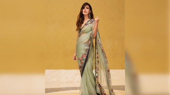 Rhea Chakraborty added more traditional charm to her look by pairing her 6-yards with statement earrings and a small bindi.(Instagram/@rhea_chakraborty)