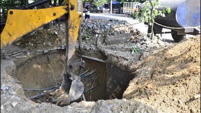 MC workers repairing the road that caved-in at Model Town extension in Ludhiana on Friday. A decade-old brick sewer collapsed and the road portion caved-in due to soil erosion. (Gurpreet Singh/HT)
