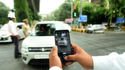 A police officer snaps a photo of a car to send an e-challan to its owner for a traffic violation in Noida on Friday. (Sunil Ghosh/HT Photo) A police officer snaps a photo of a car to send an e-challan to its owner for a traffic violation in Noida on Friday. (Sunil Ghosh/HT Photo)