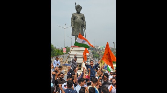 Yuva Rajput Sabha members celebrate the announcement of a public holiday on the birthday of Maharaja Hari Singh by the J & K government, near his statue in Jammu on Friday. (PTI)