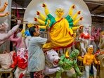 An artisan paints a clay idol of Goddess Durga at a workshop, ahead of the celebrations of Durga Puja, in Nadia, West Bengal.(PTI)