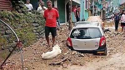 In this file image from September 10, people can be seen gathering near a vehicle that is buried under the debris on the street. (ANI)