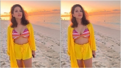 Sunny decked up in a multicoloured bra and teamed it with a pair of bright yellow shorts. She added more beach vibes with an oversized yellow shrug featuring full sleeves. (Instagram/@sunnyleone)