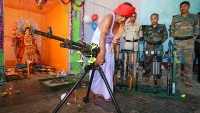 A priest worships weapons belonging to Tripura State Rifles during the Vishwakarma Puja in Agartala. (PTI)