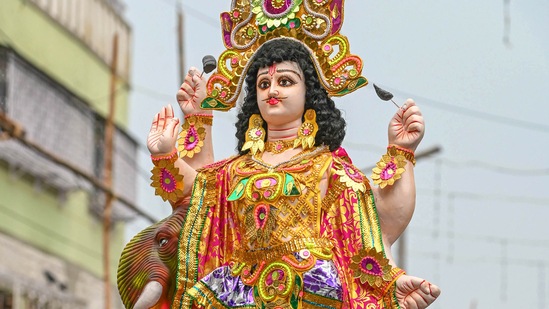 A vendor carries an idol of Lord Vishwakarma to transport it to a 'pandal', on the eve of Vishwakarma Puja festival in Kolkata.(PTI)