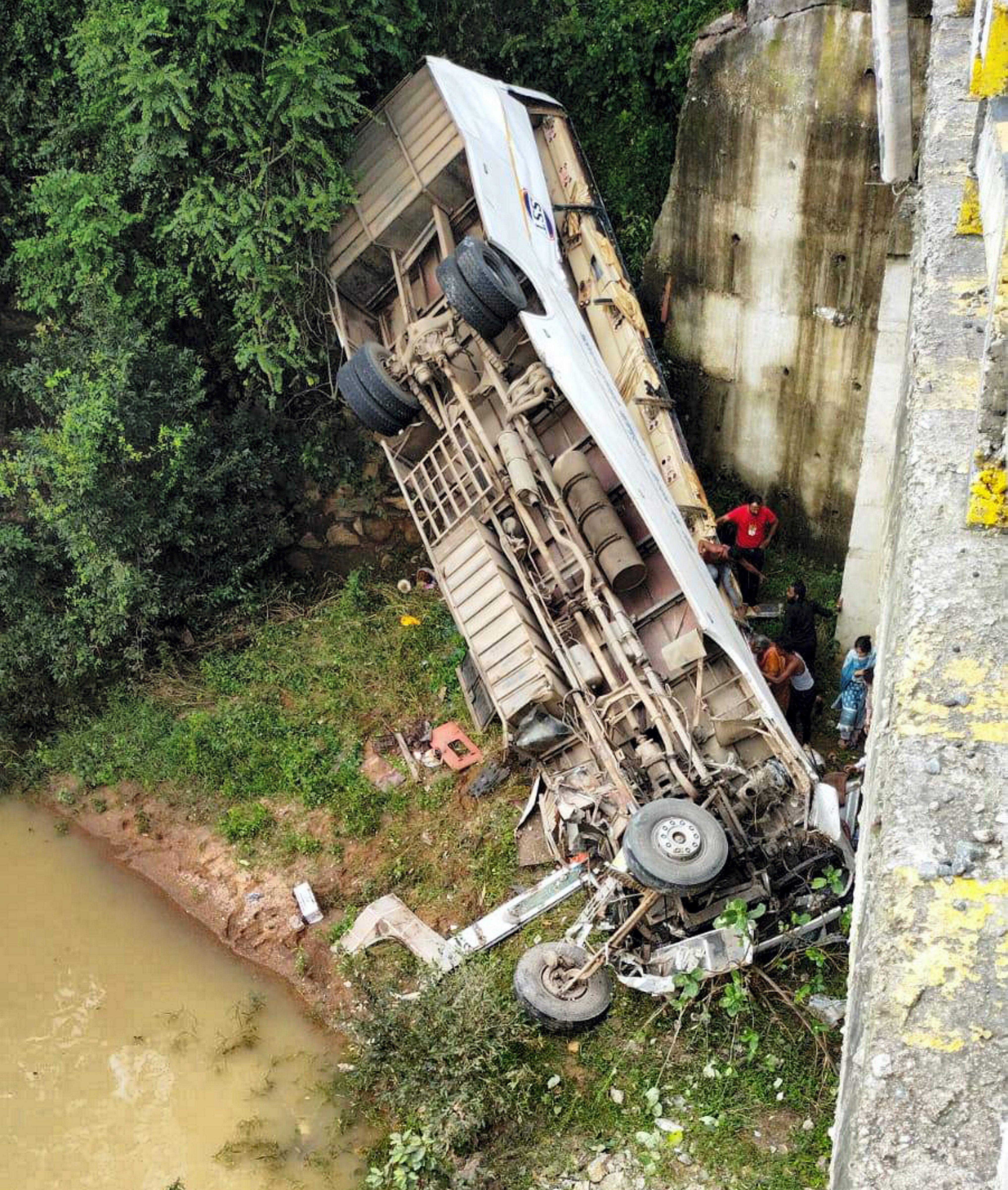 Locals try to rescue passengers after a bus fell from a bridge, in Hazaribagh district, Saturday. (PTI)