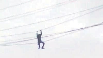 In the video grab that went viral on social media, the man can be seen hanging on to high-tension wires to save himself. (Video Grab) In the video grab that went viral on social media, the man can be seen hanging on to high-tension wires to save himself. (Video Grab)