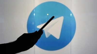 A man is seen as a silhouette as he checks a mobile device whilst standing against an illuminated wall bearing Telegram's logo in this arranged photograph in London. (Representative Image/Bloomberg) A man is seen as a silhouette as he checks a mobile device whilst standing against an illuminated wall bearing Telegram's logo in this arranged photograph in London. (Representative Image/Bloomberg)