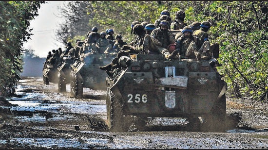 Ukrainian soldiers ride a top of infantry fighting vehicles in Novoselivka, September 17, 2022 (AFP)