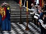 Members of the Royal family and guests sing as the coffin of Queen Elizabeth II, draped in the Royal Standard, lies by the altar during the State Funeral Service at Westminster Abbey in London. (BEN STANSALL/Pool via REUTERS)