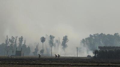 FILE PHOTO: Men walk along a field as stubble burning smoke rises, in Gharaunda in the northern state of Haryana, India, November 9, 2021. REUTERS/Anushree Fadnavis/File Photo (REUTERS)
