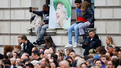 People gather, on the day of the state funeral and burial of Britain's Queen Elizabeth, at Parliament Square in London. (REUTERS)
