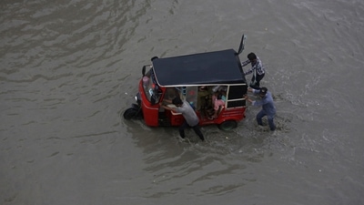 FILE - People push a rickshaw through a flooded road after a heavy rainfall in Karachi, Pakistan. (AP) FILE - People push a rickshaw through a flooded road after a heavy rainfall in Karachi, Pakistan. (AP)