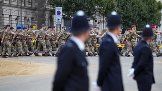 Queen Elizabeth II’s Funeral: Police watch as armed forces personnel march into position along the route that the coffin of Queen Elizabeth II will be pulled on a gun carriage.(Reuters)