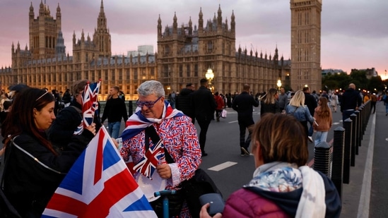 Um vendedor ambulante vende bandeiras do Reino Unido a simpatizantes na ponte de Westminster, em Londres. (AFP)