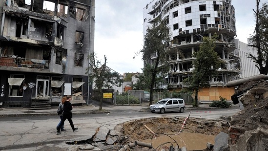 Russia-Ukraine War: People walk a destroyed building following shelling in the center of Kharkiv.