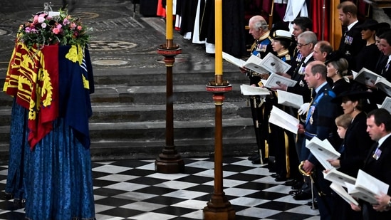 Members of the Royal family and guests sing as the coffin of Queen Elizabeth II, draped in the Royal Standard, lies by the altar during the State Funeral Service at Westminster Abbey in London. (BEN STANSALL/Pool via REUTERS)