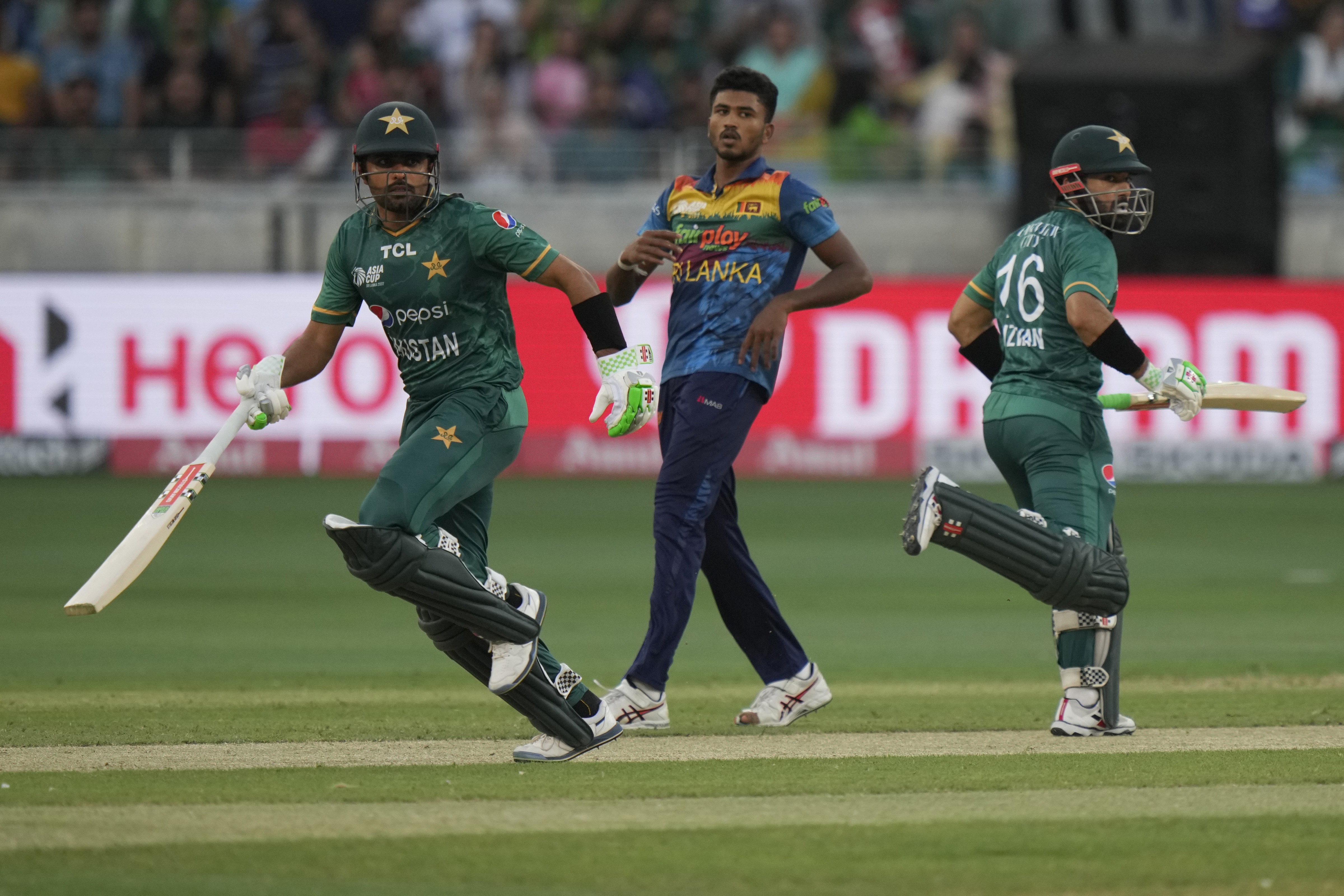 Sri Lanka's Dilshan Madushanka, center, watches as Babar Azam, left, and Mohammad Rizwan run between the wickets to score during the T20 cricket match of Asia Cup (AP)