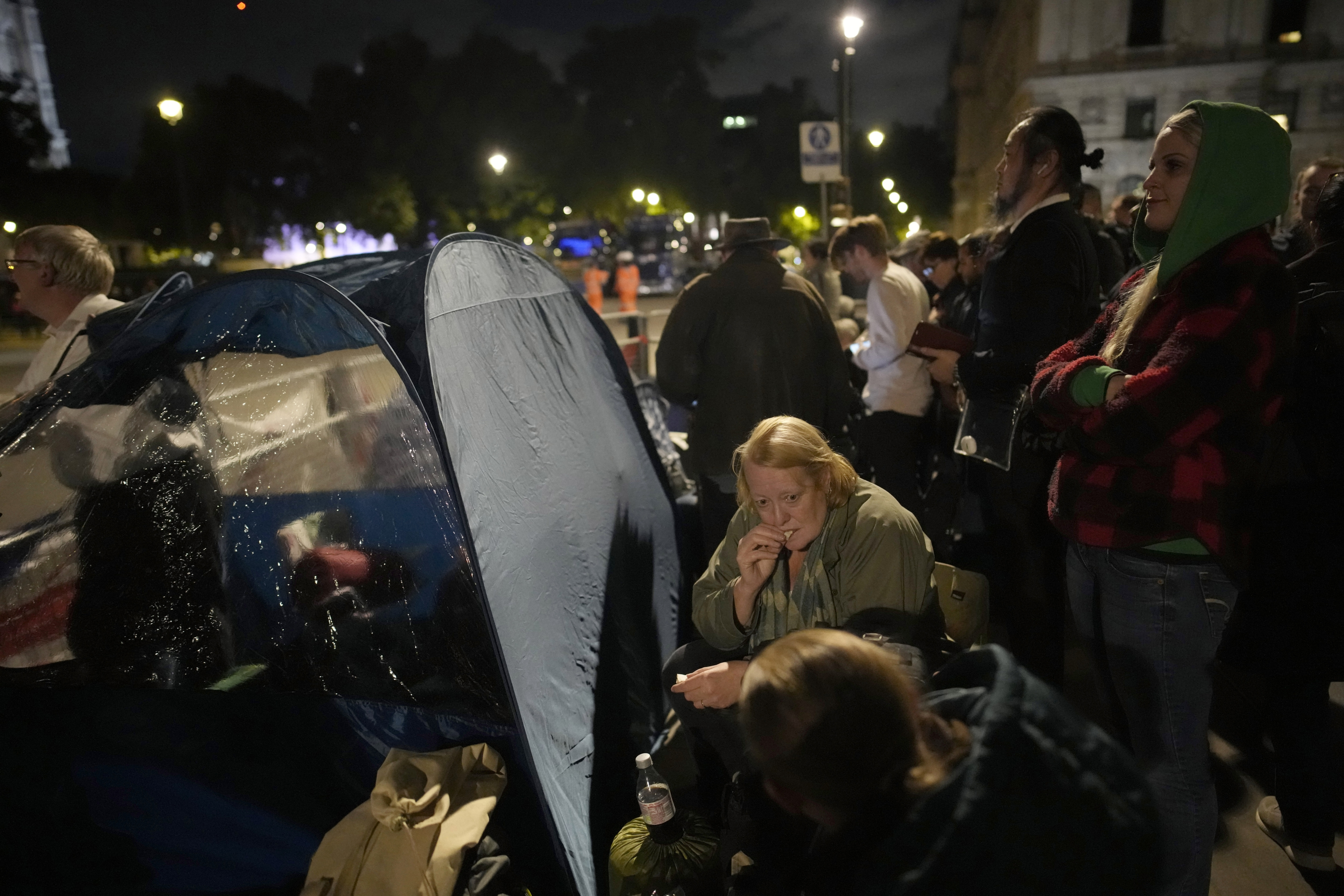 Pessoas acampam em frente ao Palácio de Westminster na véspera do funeral da rainha Elizabeth II em Londres. (AP)