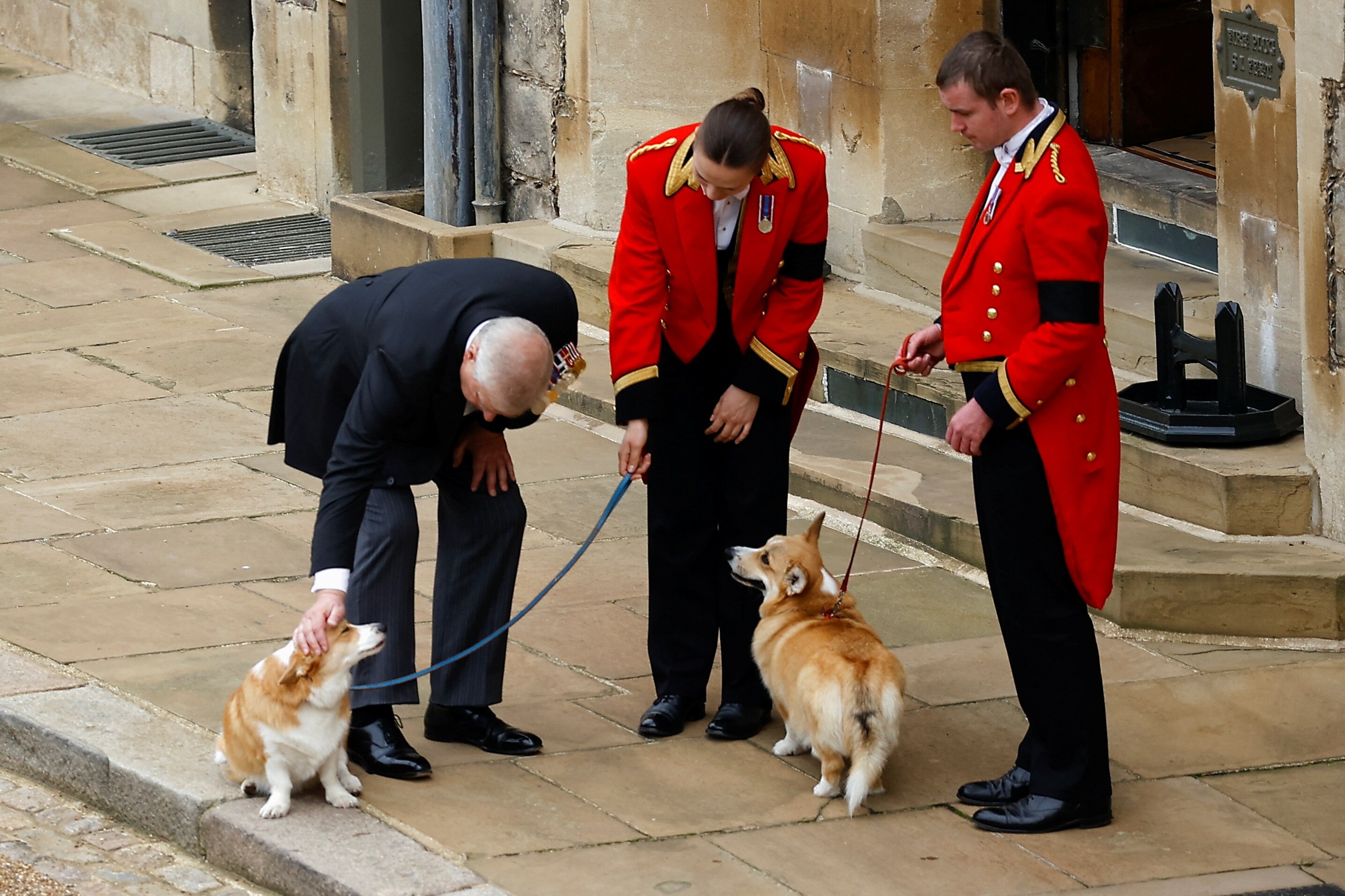 Britain's Prince Andrew pets the royal corgis Muick and Sandy on the day of the state funeral and burial of Britain's Queen Elizabeth, at Windsor Castle in Windsor, Britain. (REUTERS/Peter Nicholls/Pool)