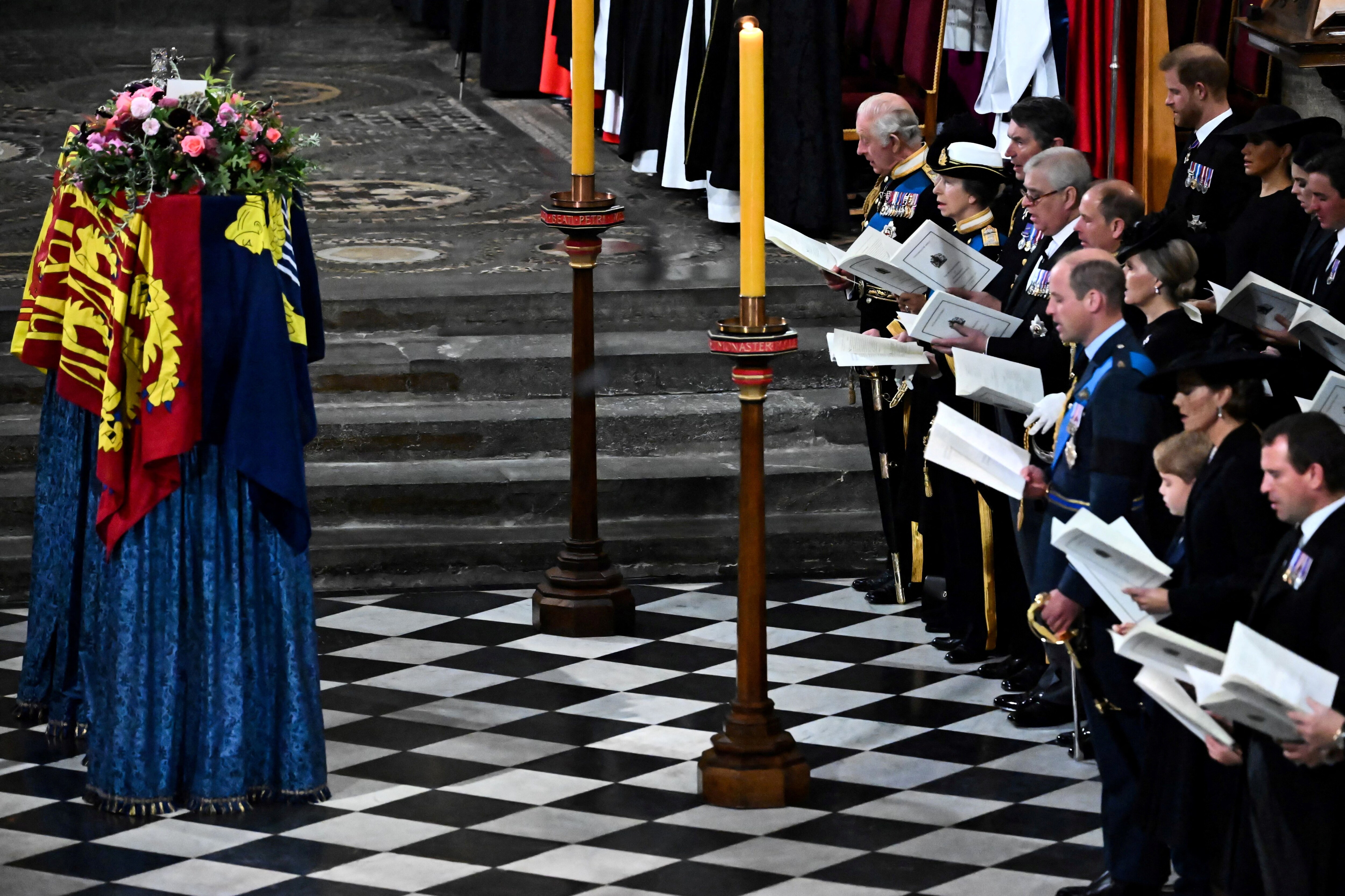Members of the Royal family and guests sing as the coffin of Queen Elizabeth II, draped in the Royal Standard, lies by the altar during the State Funeral Service at Westminster Abbey in London. (BEN STANSALL/Pool via REUTERS)