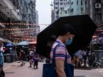 Covid In Hong Kong: A woman uses an umbrella to shield herself from the sun in Hong Kong.