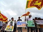 Demonstrators hols placards and Sri Lankan flags during a protest against the Sri Lankan government and for the release of student leaders in Colombo on September 9, 2022. (AFP) Demonstrators hols placards and Sri Lankan flags during a protest against the Sri Lankan government and for the release of student leaders in Colombo on September 9, 2022. (AFP)