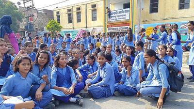 Students of Government Girls Senior Secondary School, Bahu Akbarpur, staging a protest on Hisar-Rohtak highway on Tuesday. (Manoj Dhaka/Hindustan Times)
