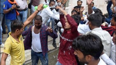 Protesting student leaders pouring kerosene like liquid over themselves near AU VC office while threatening self-immolation on Tuesday. (ht photo) Protesting student leaders pouring kerosene like liquid over themselves near AU VC office while threatening self-immolation on Tuesday. (ht photo)