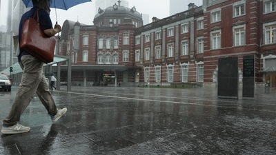 Japan Tropical Storm: A man walks towards the Tokyo train station in the rain. (AP) Japan Tropical Storm: A man walks towards the Tokyo train station in the rain. (AP)
