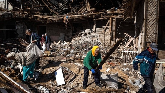 Russia-Ukraine War: Local residents collect wood for heating from a destroyed school where Russian forces were based, in the recently retaken area of Izium, Ukraine. (AP)