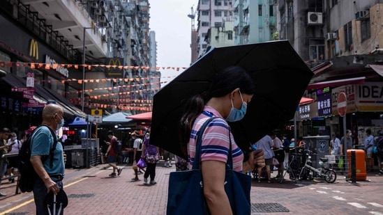 Covid In Hong Kong: A woman uses an umbrella to shield herself from the sun in Hong Kong.(AFP)