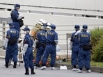 Police officers and firefighters investigate at the site where a man who was protesting a state funeral for former Japanese Prime Minister Shinzo Abe set himself on fire.