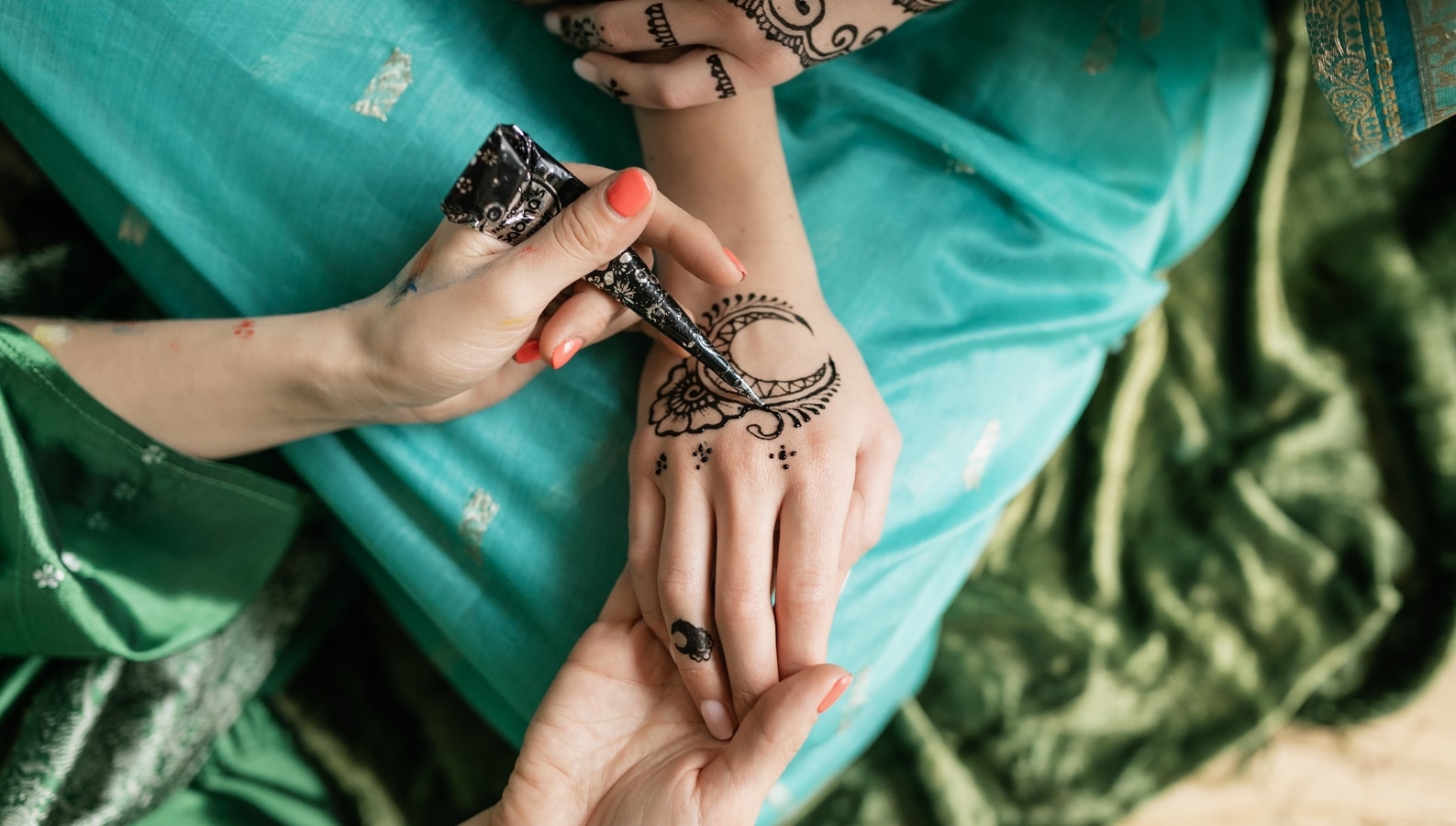 Woman with henna tattoo on hands sitting on bicycle stock photo