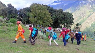 The trapped pilgrims being rescued by SDRF, NDRF personnel and local administration in Pithoragarh, Uttarakhand. (HT Photo)