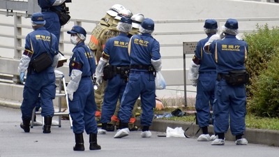 Police officers and firefighters investigate at the site where a man who was protesting a state funeral for former Japanese Prime Minister Shinzo Abe set himself on fire. (via REUTERS)