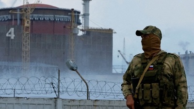 Russia-Ukraine War: A serviceman with a Russian flag on his uniform stands guard near the Zaporizhzhia Nuclear Power Plant. (Reuters)