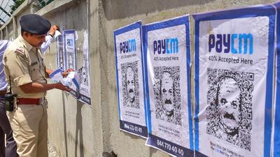 A police removes 'PayCM' posters, in Bengaluru. (PTI) A police removes 'PayCM' posters, in Bengaluru. (PTI)